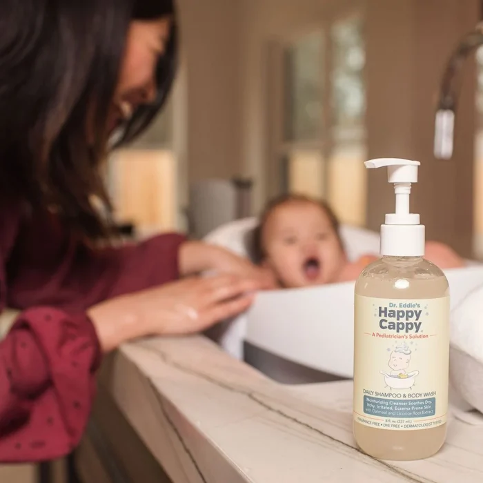 Mother bathing her baby with the Happy Cappy daily wash bottle on the tub ledge